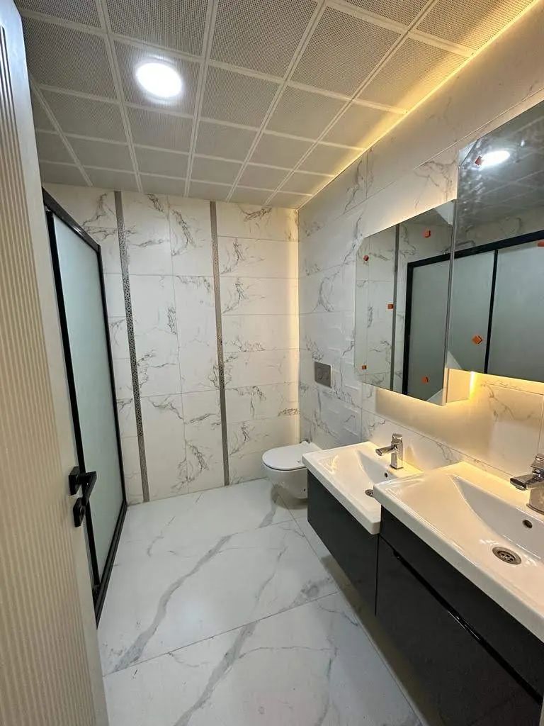 Mermer kaplı banyo ve çift lavabo