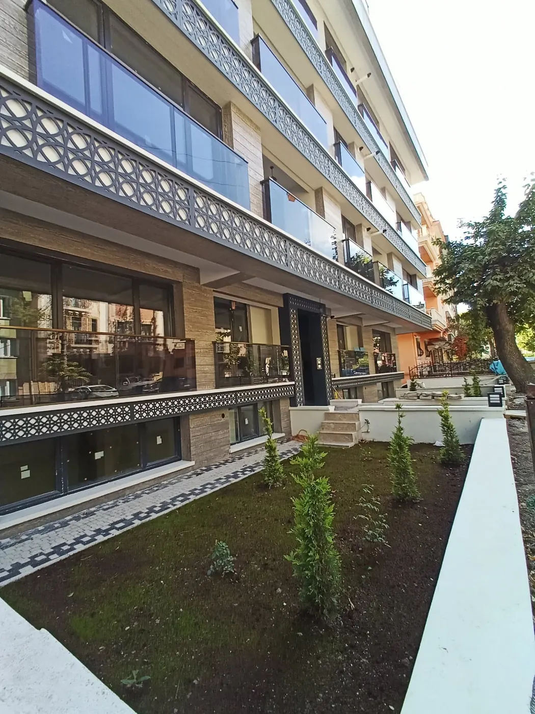 Süslemeli cepheli apartman, bahçeden görünüm