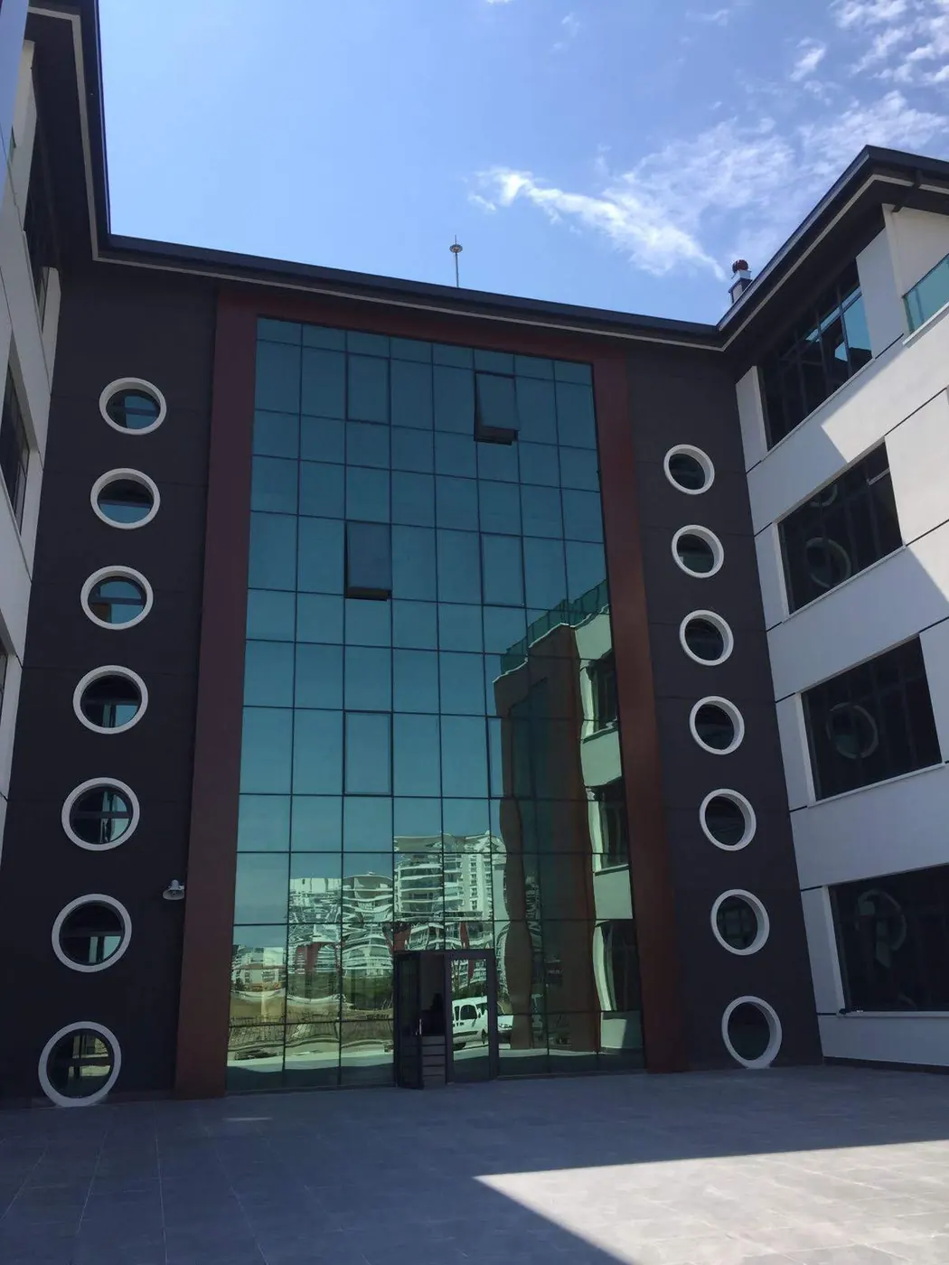 Yuvarlak pencere detaylı cam cepheli bina, ön cephe