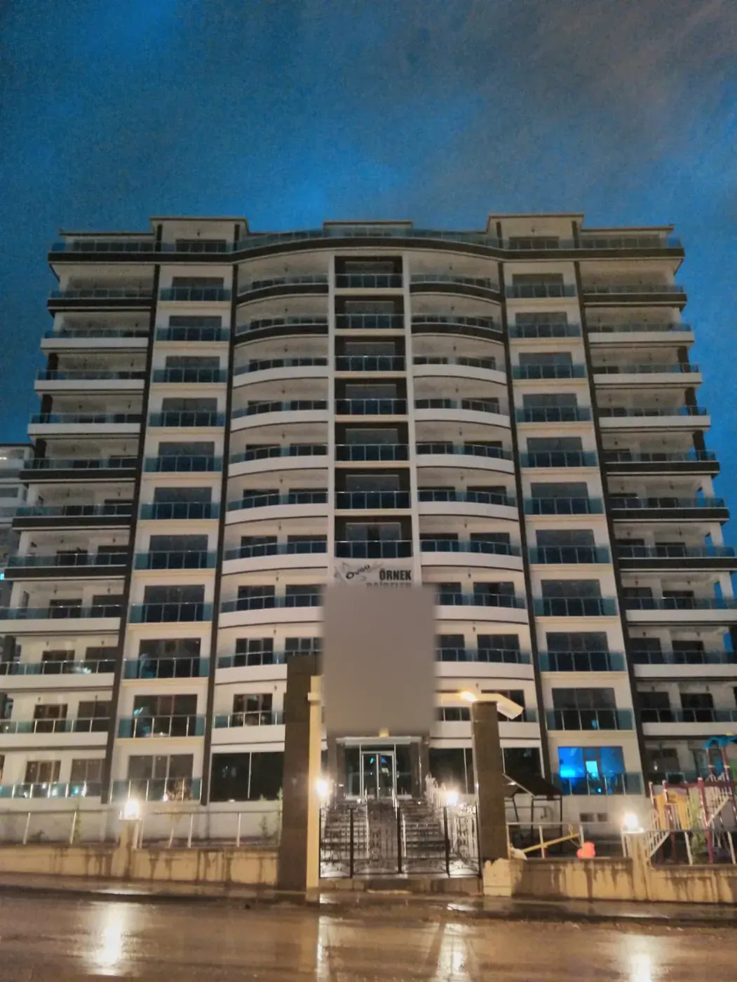 Yüksek katlı konut binasının giriş cephesi, akşam görünümü