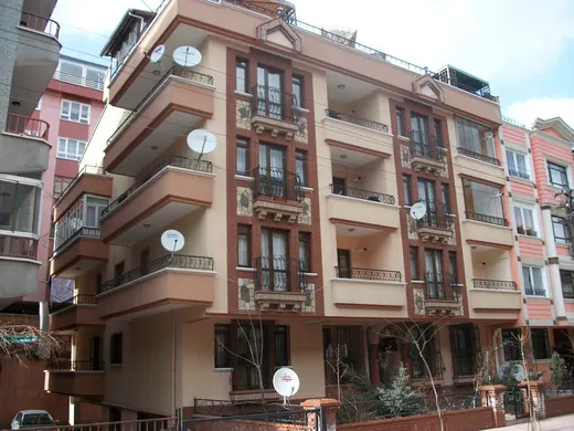 Tuğla şeritli ve balkonlu Övgü apartmanı cephesi