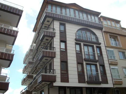 Kemerli pencereli, kahverengi şeritli apartman cephesi